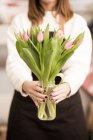 Mulher segurando tulipas rosa fresco no frasco — Fotografia de Stock