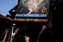 Анонімні люди руки на вулиці під пофарбованою дерев'яною дошкою, що висить . — стокове фото