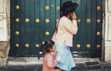 Ayacucho, Peru - 30. Dezember 2016: Mutter geht mit Kind in Strassenanzeige und telefoniert — Stockfoto