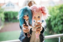 Fermez les mains féminines tenant deux poupées — Photo de stock