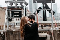 Paar umarmt sich auf dem Dach und Mädchen küsst Freund auf die Stirn. — Stockfoto