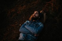 Bearded man lying on ground in autumn forest. — Stock Photo