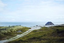 Vista para estrada indo para casa solitária no litoral . — Fotografia de Stock