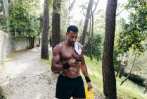 Muscular man using smartphone — Stock Photo