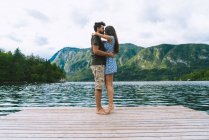Paar umarmt sich auf Seebrücke — Stockfoto