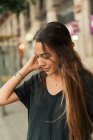 Ritratto di ragazza bruna in posa con mano nei capelli sulla scena della strada — Foto stock
