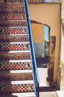 Sunlit stairs decorated with ceramic tiles over archway — Stock Photo