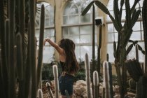 Брюнетка дівчина позують з озброєнь розкритими у ботанічному саду — стокове фото