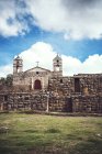 Antique church placed on ancient temple ruins over cloudscape — Stock Photo