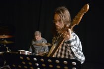 Чоловік грає на бас-гітарі з гуртом на сцені — стокове фото