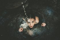 Mädchen sitzt in Brunnen und übergießt sich mit Milch — Stockfoto