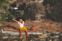 Дівчина в костюмі Хеллоуїна сидить на даху — стокове фото