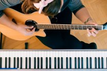 Giovane donna che registra chitarre e pianoforte presso il suo Home Sound Studio. — Foto stock