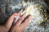 Vue ci-dessus des mains frappant la pâte pour gâteau au citron sur la table en bois rurale — Photo de stock