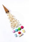 Candies with popcorn path to paper cone — Stock Photo