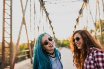 Punk teen girls laughing on a bridge. — Stock Photo