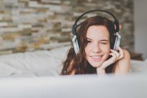 Woman with headphones squinting at camera — Stock Photo