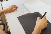 Mani femminili con tastiera e tablet grafico — Foto stock