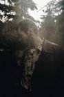 Человек, стоящий в лесу на фоне дыма — стоковое фото