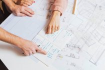 Top view of hands of male and female designers working with the plan — Stock Photo