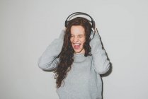 Femme dans les écouteurs profitant de la musique avec bouche ouverte — Photo de stock