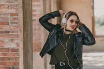 Girl in headphones posing with bended raised arms — Stock Photo