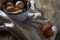 Natureza morta de ovos de galinha em tigela de metal na mesa rural — Fotografia de Stock