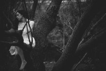 Chica dramática posando en rama de árbol - foto de stock