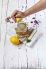 Male hand squeezing lemon in jar — Stock Photo