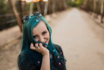 Girl with confetti in blue hair looking at camera — Stock Photo