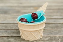 Fresh cherries in ice cream shape bowl and spoon — Stock Photo