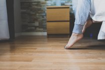 Weibliche Füße treten vom Bett auf den Boden — Stockfoto