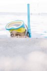 Enfant en masque de plongée avec tuba posant au bord de la piscine et regardant de côté — Photo de stock