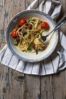 Spaghetti e polpette guarnite con foglie di basilico e pomodori grigliati su piatto — Foto stock