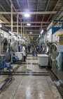 TANGIER, MARRUECO- 18 de abril de 2016: Máquinas industriales en líneas y trabajadores de la confección fabrica - foto de stock