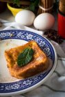 Vista da vicino del toast dolce con foglia di menta su piatto ornato su stelle di anice e uova sullo sfondo — Foto stock