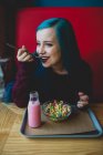 Menina com cabelos azuis comendo rebanhos — Fotografia de Stock