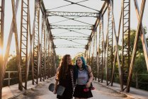 Mädchen umarmen sich auf Brücke — Stockfoto