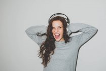 Mulher em fones de ouvido curtindo música com boca aberta — Fotografia de Stock