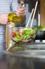 Кукурудза жінка додає оливкову олію в миску салату — стокове фото