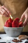 Erntebild weiblicher Hände, die Erdbeeren in Schale auf den Tisch mit Anissternen und Schaufel legen — Stockfoto