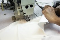 Mãos de lavrador usando máquina de costura na planta — Fotografia de Stock