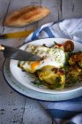 Coltello da raccolto affettare uovo fritto e patate in piatto di ceramica — Foto stock