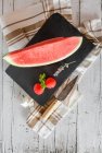 Wedge of fresh watermelon and strawberries on slate — Stock Photo