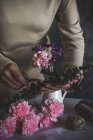 Section médiane de fleur de coupe de fleuriste femelle avec des ciseaux dans le vase — Photo de stock