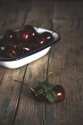 Still life of cherries on rural wooden table — Stock Photo