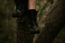 Crop female leg in boot hanging from tree — Stock Photo