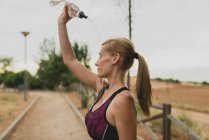 Sportswoman verser de l'eau sur le visage — Photo de stock