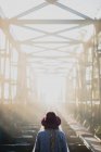 Frau mit Hut läuft auf Eisenbahnbrücke — Stockfoto
