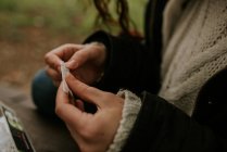 Cultivo manos femeninas rodando cigarrillo en la naturaleza - foto de stock